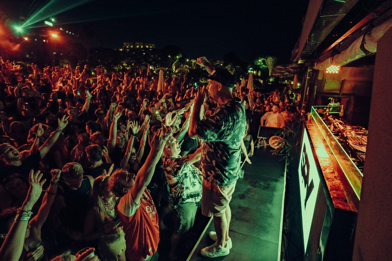 DJ actuando en LOCUS Bali 2025, con el público vibrando bajo luces doradas