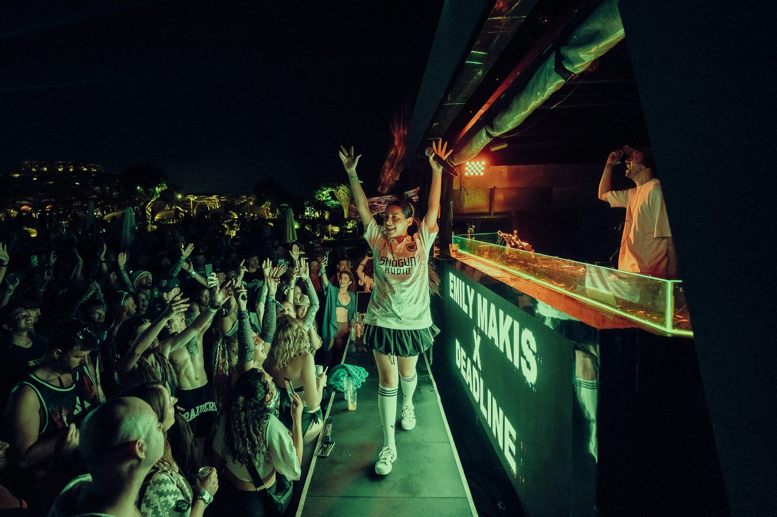 MC entrando al escenario ante un público iluminado en verde, LOCUS Bali 2025
